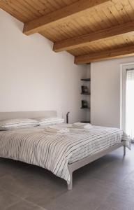 uma cama num quarto branco com tecto em madeira em Come a casa - Feels like home em Polignano a Mare
