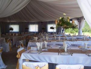 a large tent with white tables and chairs at Restaurant-Pensiune La Danila in Zolt