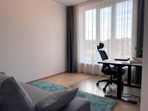 een woonkamer met een bank en een bureau met een laptop bij A stylish & cozy terraced house in Tartu in Tartu
