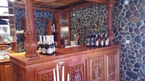 a bar with a bunch of bottles on a counter at Restaurant-Pensiune La Danila in Zolt