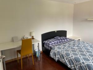 1 dormitorio con cama, escritorio y silla en Homehouse en Toronto