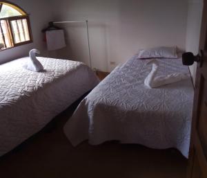 Cucaita的住宿－MI CABAÑA DE DESCANSO，卧室里床边的两只天鹅