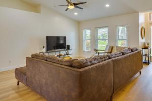 a large brown couch in a living room with a flat screen tv at Pet-Friendly Cape Coral Vacation Rental with Lanai! in Cape Coral