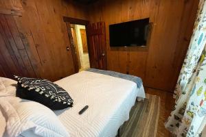 a bedroom with a bed and a flat screen tv at Downtown-Urban Cabin Unique Stay in Murfreesboro