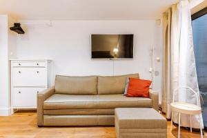 a living room with a couch and a tv at Hermitage Road Apartment By Morethanstays in London