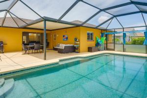 a large swimming pool with a patio and a house at Pet-Friendly Cape Coral Vacation Rental with Lanai! in Cape Coral