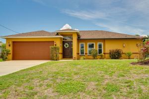 a yellow house with a garage at Pet-Friendly Cape Coral Vacation Rental with Lanai! in Cape Coral