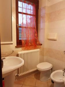 baño con lavabo y aseo y ventana en Villa Rosa, en Gaglietole