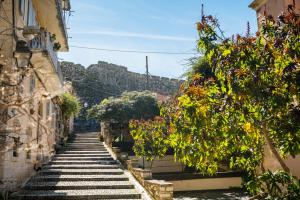 een steile trap tussen twee gebouwen met bloemen bij Corfu Lux City in Ágios Rókkos