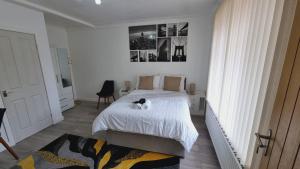 um quarto com uma cama com um gato sentado nela em Modern 3 bedroom house, 3 Bathroom, secure parking, Wi-Fi & Garden em Leeds