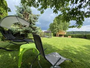 a couple of chairs sitting in the grass at Villa DonLeone in Ponikva