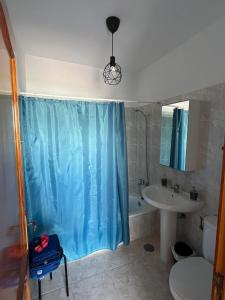 a bathroom with a blue shower curtain and a sink at Casa Noas in Playa Blanca