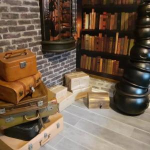 un montón de equipaje sentado en el suelo en una biblioteca en Appart Aventure, logement entier + escape game !, en Reims