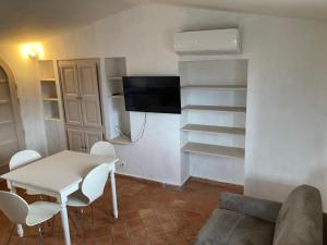 - un salon avec une table, des chaises et une télévision dans l'établissement Appartement de Charme au calme Parking gratuit, à La Colle-sur-Loup