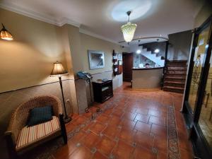 a hallway with a couch and a lamp and stairs at Hostal Jayma in Salobreña