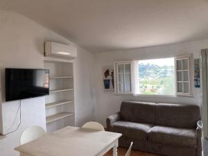 - un salon avec un canapé et une table dans l'établissement Appartement de Charme au calme Parking gratuit, à La Colle-sur-Loup