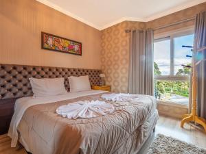 - une chambre avec un grand lit et une fenêtre dans l'établissement Vale das Hortênsias 204 II, à Gramado