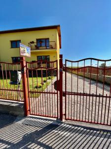 a gate in front of a yellow building at Privat u Eriky in Stará Lesná