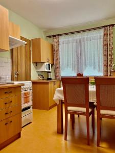 a kitchen with a table and chairs and a window at Privat u Eriky in Stará Lesná