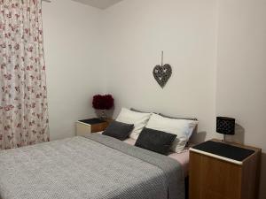 una camera con letto e cuore sul muro di Annamaria Home a Pola (Pula) Altre 38 foto