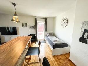 a living room with a table and a bed in it at Penthouse mit Blick auf den Yachthafen in Bremen