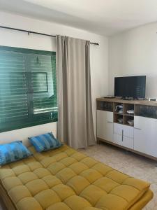 a bedroom with a bed and a flat screen tv at Casa Noas in Playa Blanca