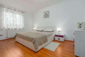 Nova Vas的住宿－Villa Lori，一间铺有木地板的白色卧室,配有一张床