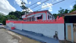 una casa con un muro rosso e bianco di Mack's Home a Clifton