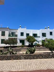 a large white building with trees in front of it at Casa Noas in Playa Blanca