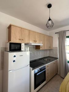 a kitchen with a white refrigerator and a microwave at Casa Noas in Playa Blanca