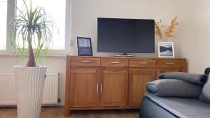 a living room with a tv on a wooden cabinet at Gemütliche Auszeit in der Eifel in Mechernich