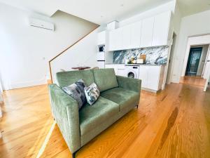 ein Wohnzimmer mit einem grünen Sofa und einer Küche in der Unterkunft Vibrant Porto Apartments-Bonfim in Porto
