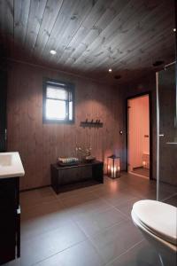 uma casa de banho com um quarto com uma banheira e uma janela em Strandafjellet Panorama Lodge - Large Cabin with Majestic Mountain View em Stranda
