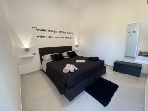 a bedroom with a black bed with shoes on it at El Puerto B&B in Vieste
