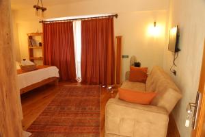 uma sala de estar com um sofá, uma cadeira e uma cama em Istlada Taş Ev Apart - Kekova View em Antalya