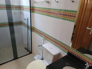 a bathroom with a toilet and a glass shower at Rio Quente Thermas Paradise in Rio Quente
