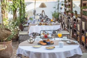 a table with breakfast food on it in a restaurant at Hotel & Spa Riad El Walaa in Marrakesh