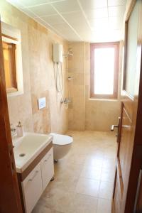 uma casa de banho com um lavatório, um WC e uma janela. em Istlada Taş Ev Apart - Kekova View em Antalya