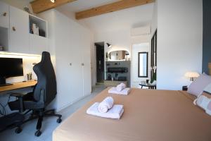 a room with a desk and a bed with towels on it at Maison de village rénovée ! in Le Grau-du-Roi