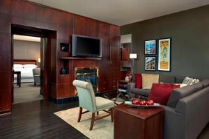 a living room with a couch and a tv at Sheraton Suites Calgary Eau Claire in Calgary