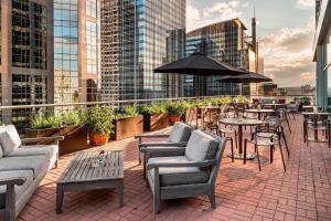 a rooftop patio with tables and chairs and an umbrella at Sheraton Suites Calgary Eau Claire in Calgary