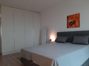 a bedroom with a large bed and a white wall at Port Lozenets Apartment in Lozenets
