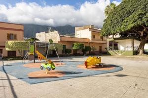 un parque infantil con dos equipos de juego en un aparcamiento en Casa Rural Teresita Entera Tranquila Llena de Bienestar, en Güímar