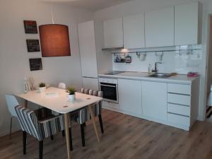 a kitchen with white cabinets and a table with chairs at Port Lozenets Apartment in Lozenets