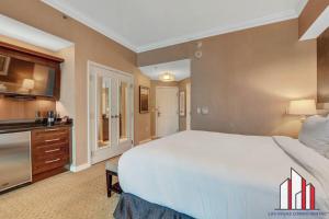 um quarto grande com uma cama grande e uma televisão de ecrã plano em MGM Signature-32-715 F1 Track & Strip View Balcony em Las Vegas