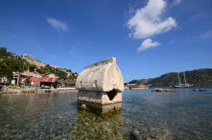 un pilar de piedra en el agua en un cuerpo de agua en Istlada Taş Ev Apart - Kekova View, en Antalya