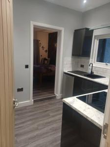 a kitchen with a sink and a counter top at Beautiful MASONS HIDEAWAY studio apartment in Bridgend