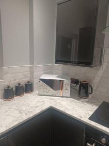 a kitchen counter with a microwave on top of it at Beautiful MASONS HIDEAWAY studio apartment in Bridgend