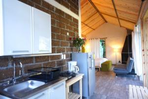 a kitchen with a refrigerator and a brick wall at Cabaña El Encino II En Real del Monte in Mineral del Monte +13 photos
