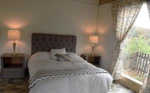 Un dormitorio con una cama grande y una ventana en El Encino Cabin in Real del Monte, en Mineral del Monte